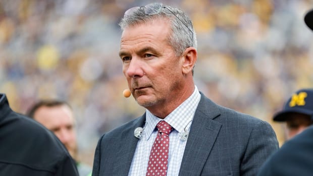 FOX Sports college football analyst Urban Meyer walks along the sideline before a game between Michigan and Maryland at Michigan Stadium in Ann Arbor.